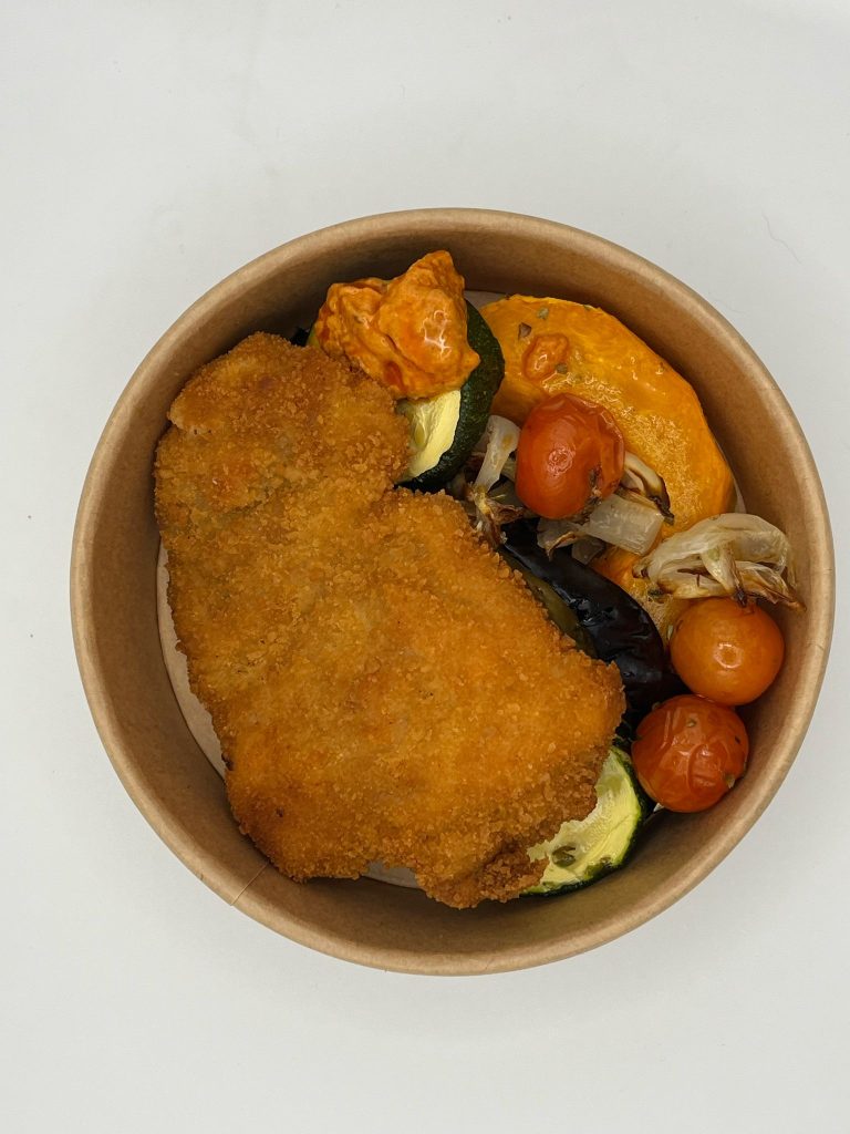 Milanesa de pollo con verduras al horno y salsa romesco